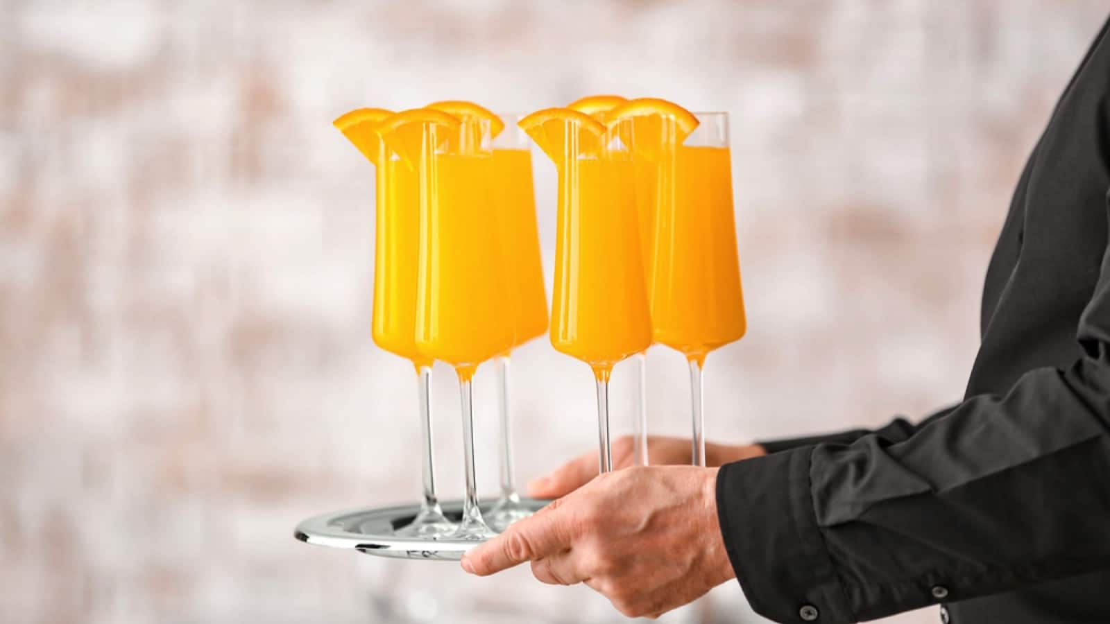 Man holding Mimosa cocktail