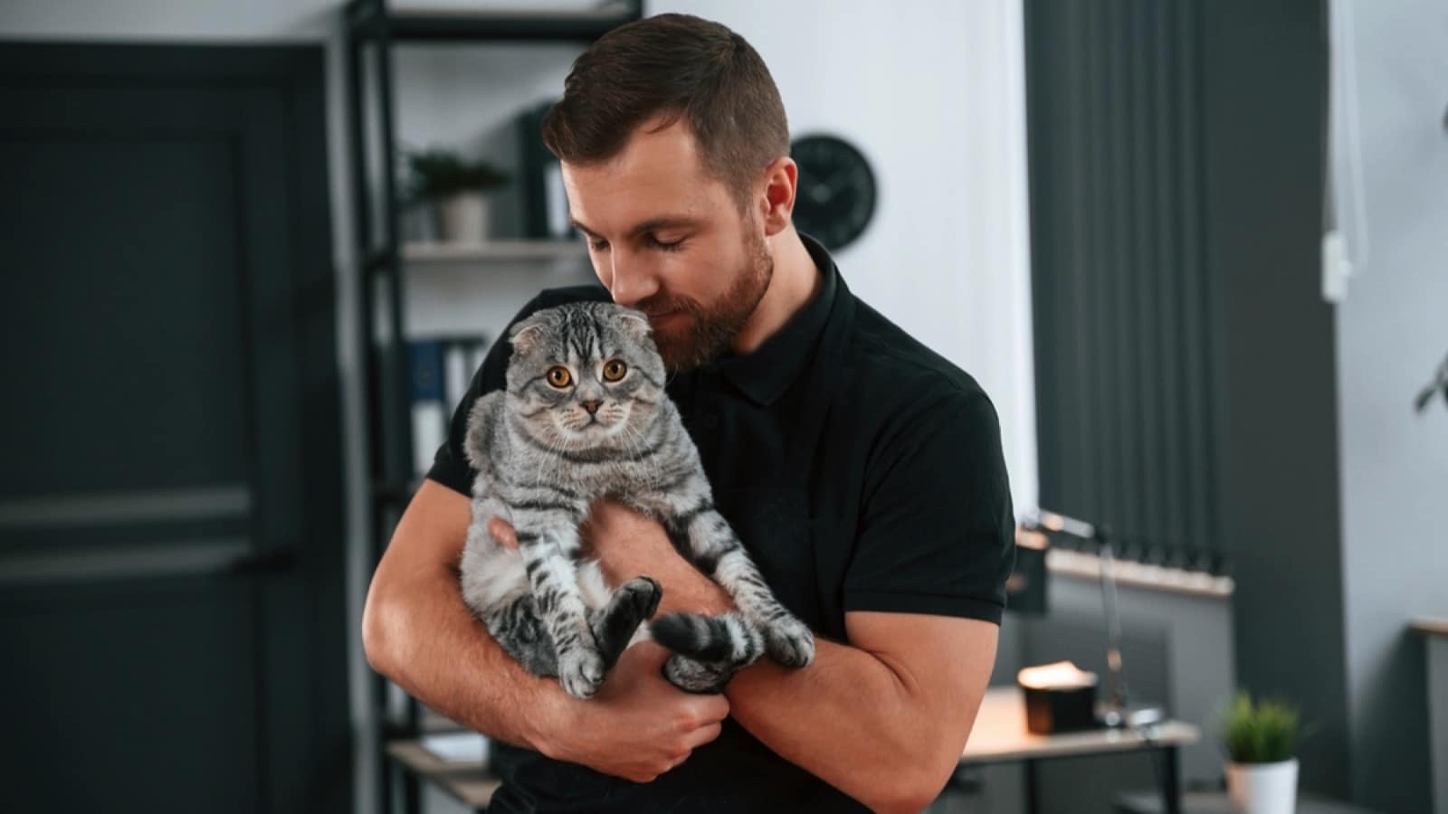 Man holding cat in hand