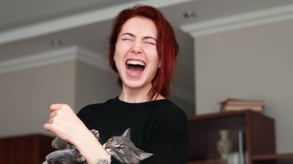 Woman getting lovebite from cat