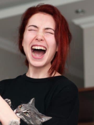 Woman getting lovebite from cat