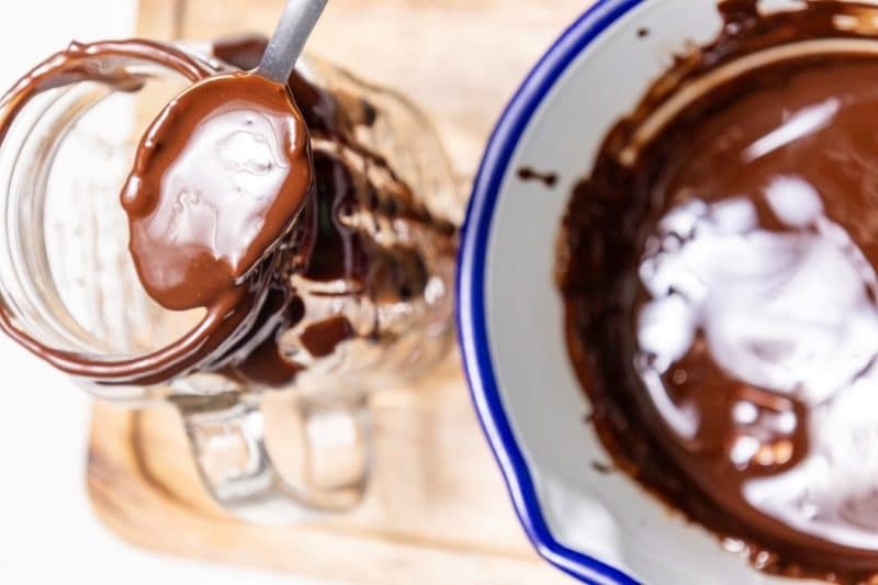 cover a glass with chocolate sauce to make a freakshake