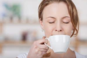 woman blissfully drinking coffee